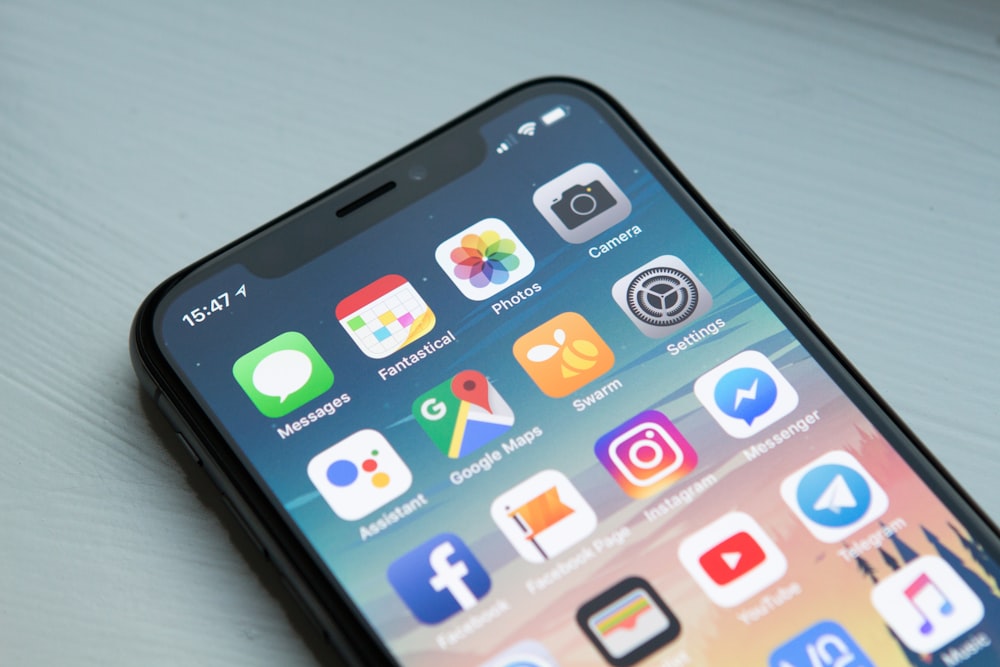 Smartphone on a desk showing a grid of app icons