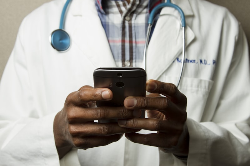 Clinician in a white coat using a mobile phone