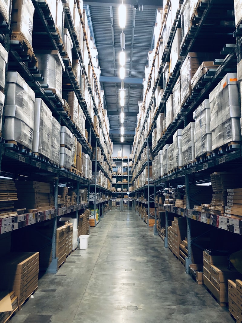 Warehouse aisle lined with tall racking and palletized stock